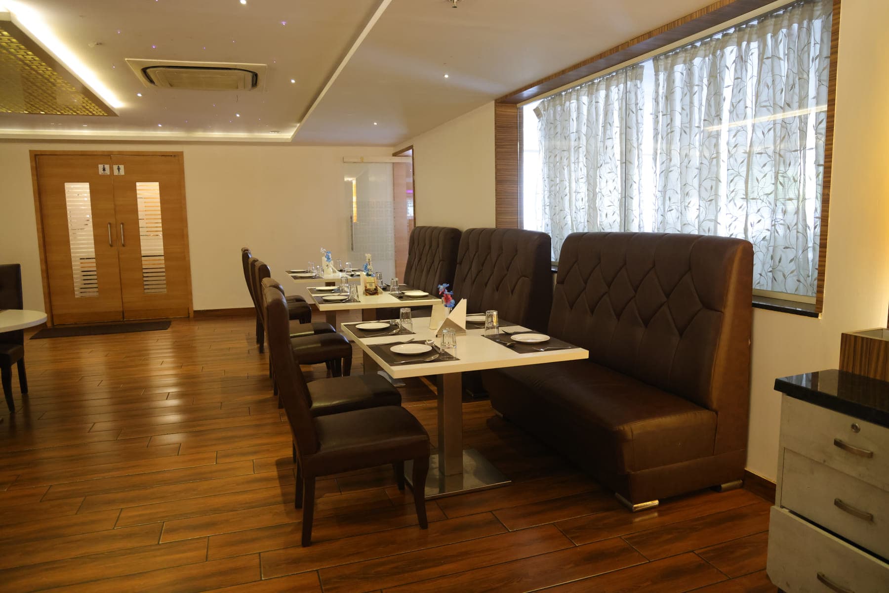 The restaurant laid out for service, with booth seating along a wood-panelled wall