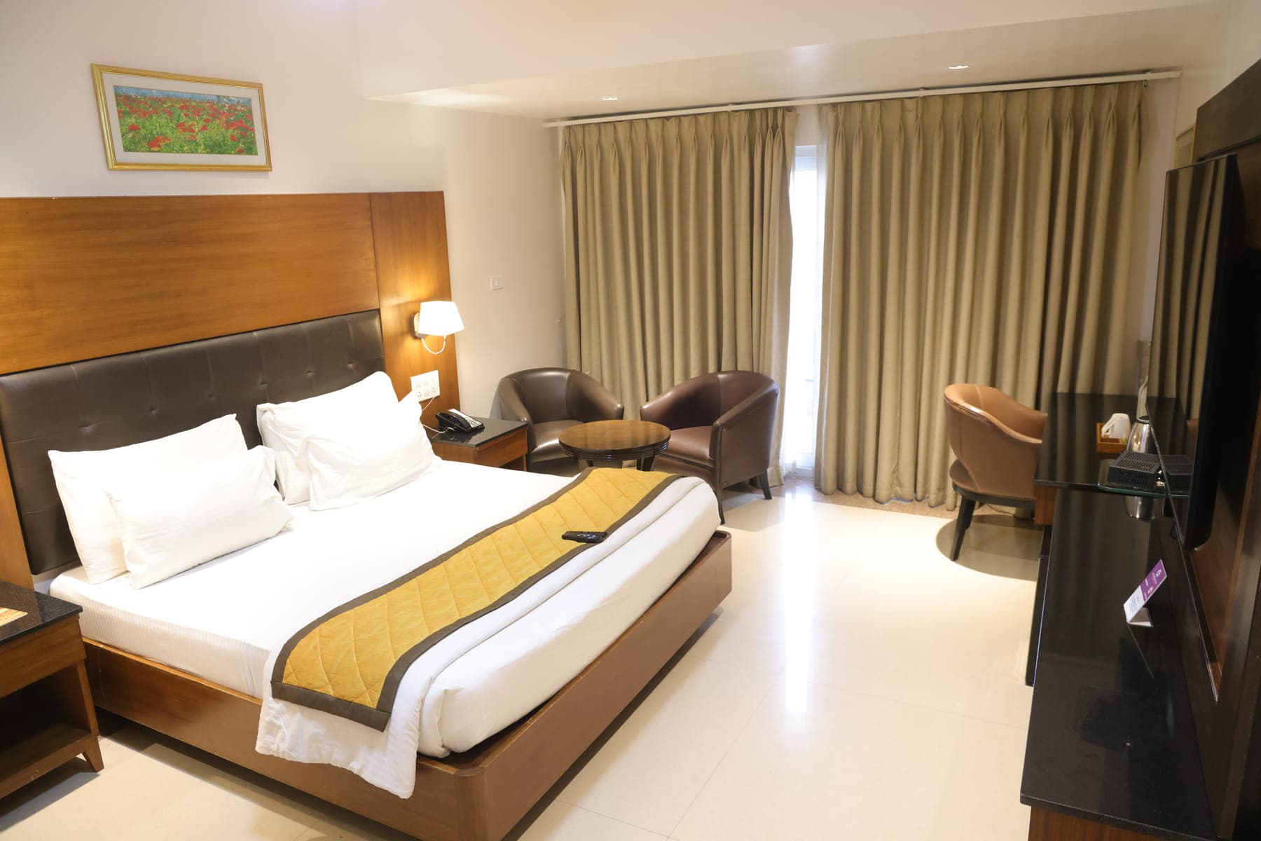 The bedroom of the Executive Suite, with a king bed and a window overlooking the street