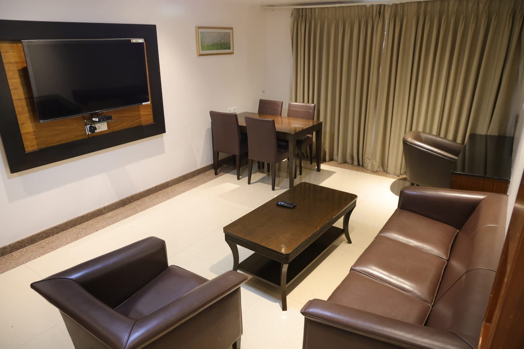 The living room of the Executive Suite, with leather sofas, a coffee table and a dining table